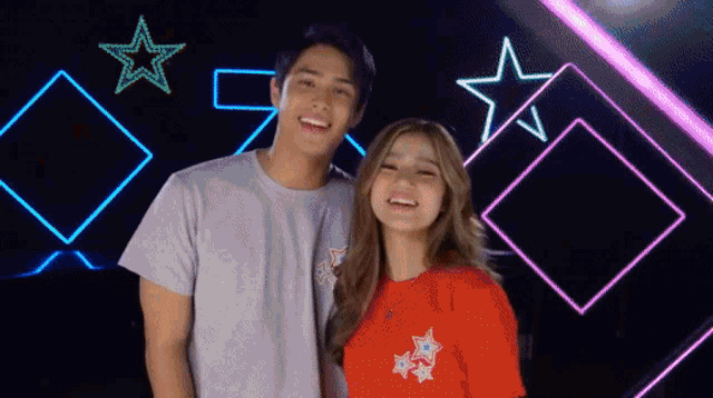 a man and a woman are standing next to each other smiling