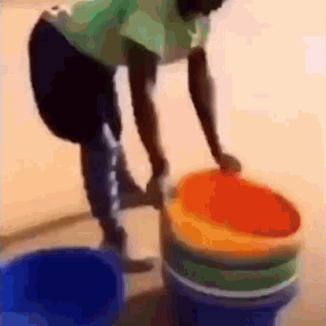 a blurry picture of a person stacking buckets on top of each other .