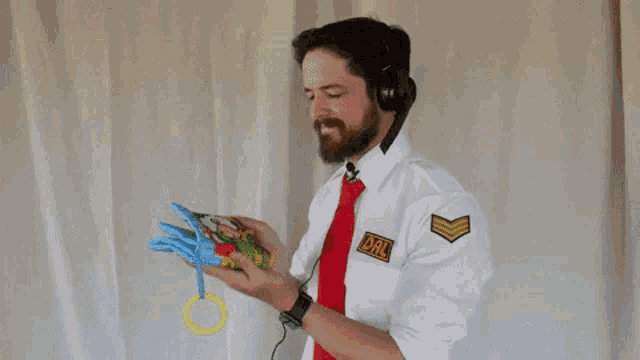 a man in a white shirt and red tie is holding a baby book .