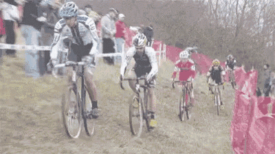 a group of people are riding bikes down a dirt road .