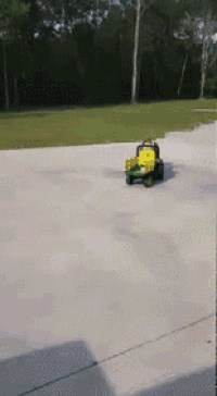 a toy tractor is driving down a driveway