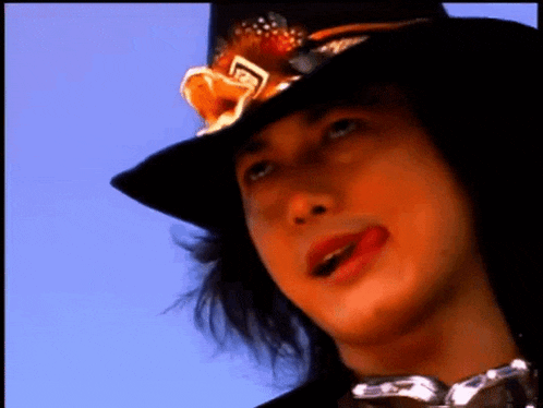 a close up of a person wearing a hat with a flower on it