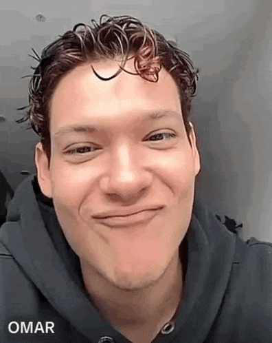 a man with curly hair is making a funny face .