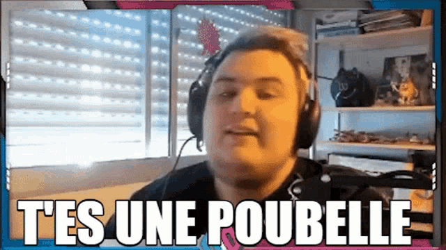 a man wearing headphones says " tes une poubelle " in a video
