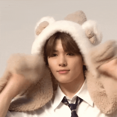 a young man wearing a furry hat and tie