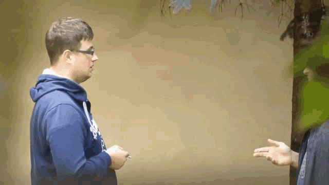 a man wearing a blue sweatshirt that says ' abercrombie & fitch ' on it is talking to another man