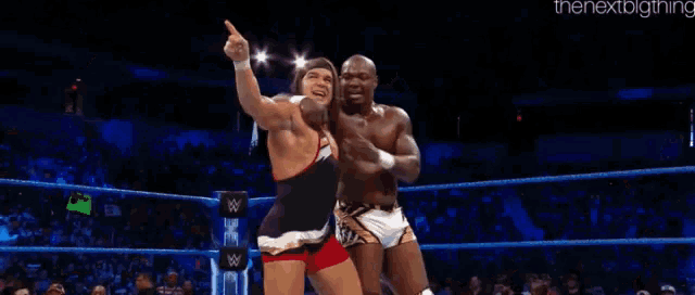 two wrestlers are fighting in a wrestling ring .