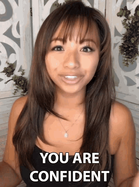 a woman in a black tank top is smiling and says you are confident