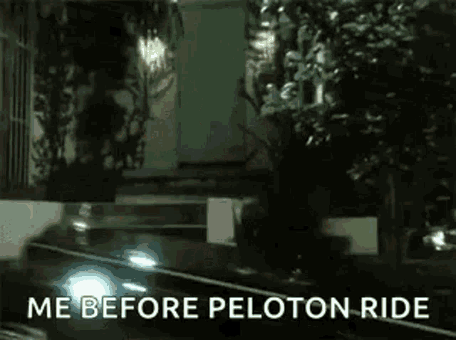 a car is driving down a street at night with the words `` me before peloton ride '' .