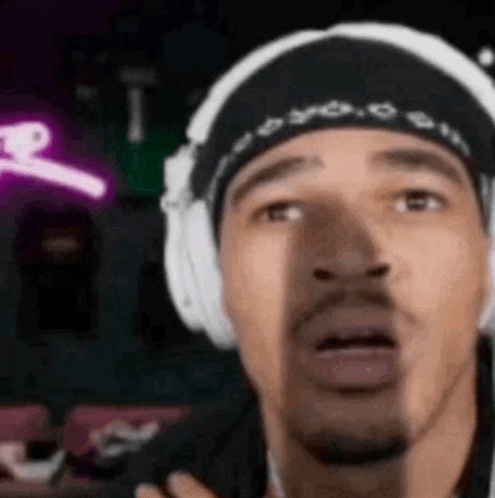 a close up of a man wearing headphones and a bandana .