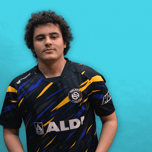 a man wearing a black and yellow shirt that says aldi on it