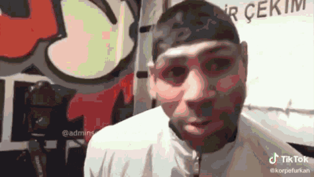 a man 's face is shown in front of a sign that says " tik tok "
