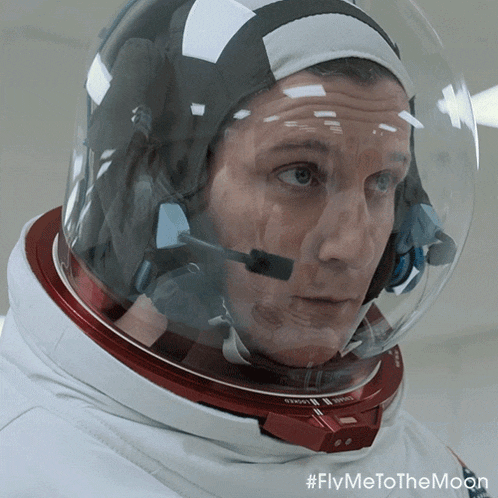 a close up of a man wearing a helmet with the words fly me to the moon