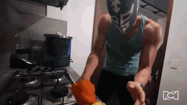 a man wearing a mask is cooking on a stove with the letters dc on the wall behind him