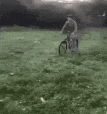 a person is riding a bike on a grassy field .