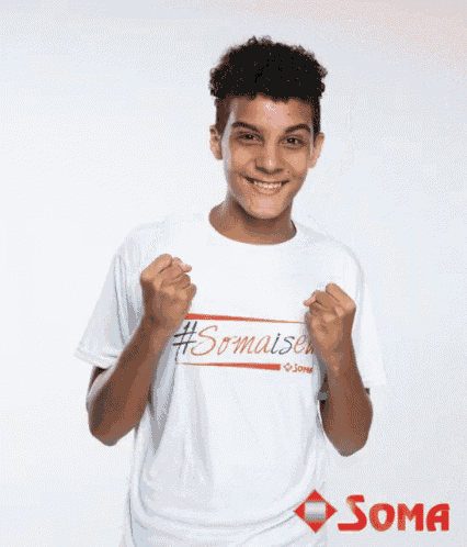 a young man wearing a soma t-shirt is smiling