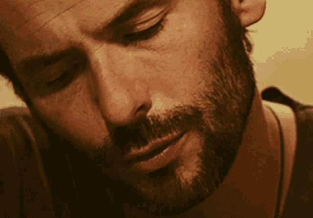 a close up of a man 's face with a beard