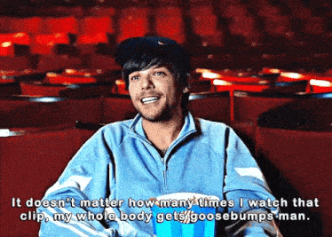 a man in a blue jacket is sitting in an auditorium with a popcorn bucket and says it does n't matter