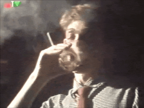 a man is smoking a cigarette and drinking a glass of beer