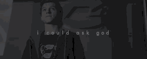 a man in a hoodie is standing in a dark room with the words `` i could ask god '' written above him .
