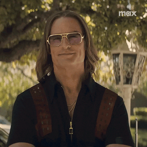 a man wearing sunglasses and a black shirt has the word max on the bottom