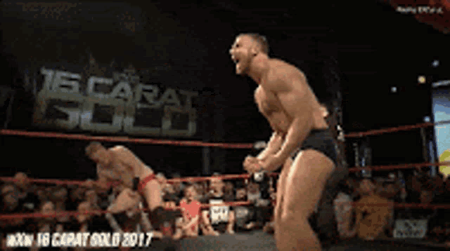 a man in a wrestling ring with a sign that says 15 carat gold on it