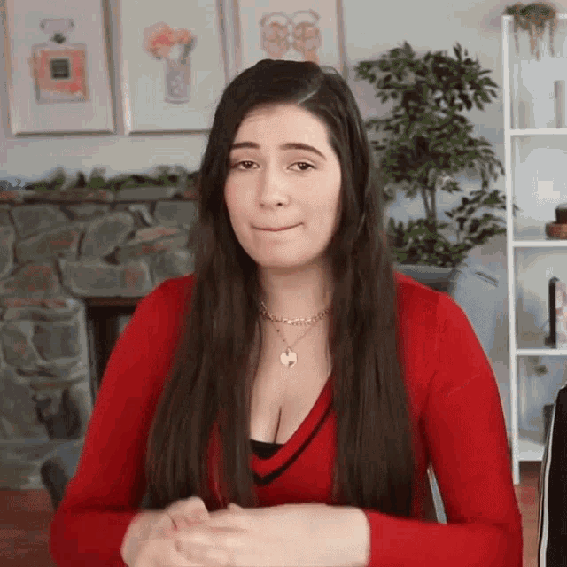 a woman wearing a red sweater and a gold necklace