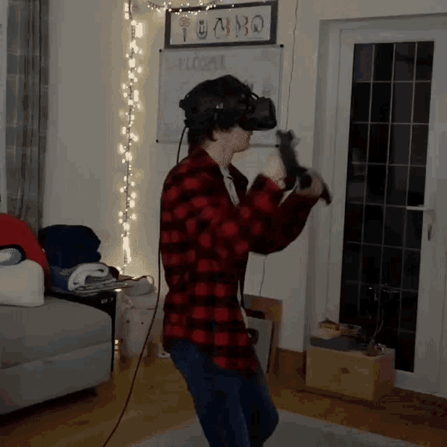 a man wearing a virtual reality headset is dancing in a living room .