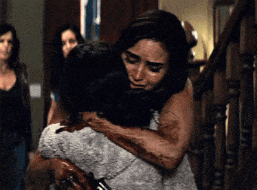a woman is hugging another woman with blood on her face