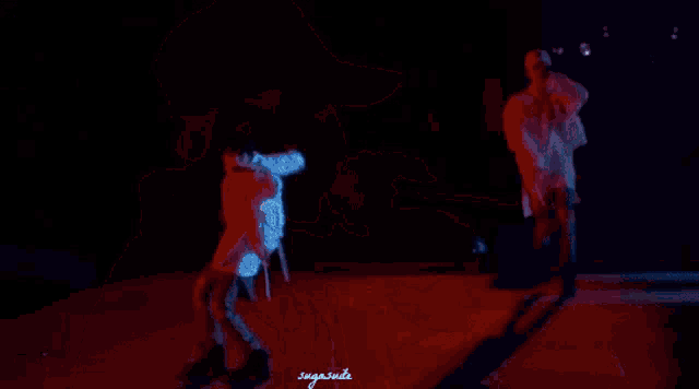 two men are dancing on a stage with the words sugainside written on the bottom right