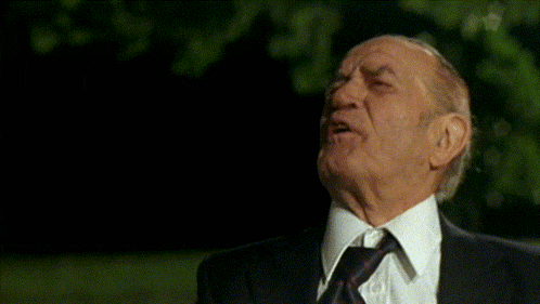 an old man in a suit and tie is laughing