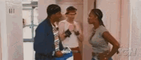 two men and a woman are standing in a hallway talking to each other with a gn logo behind them