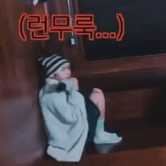 a person is sitting on the floor with their legs crossed and a blanket around their neck .