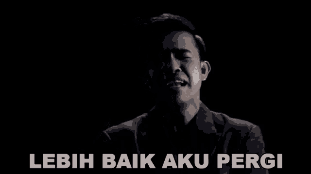 a man in a suit is singing with the words lebih baik aku pergi behind him