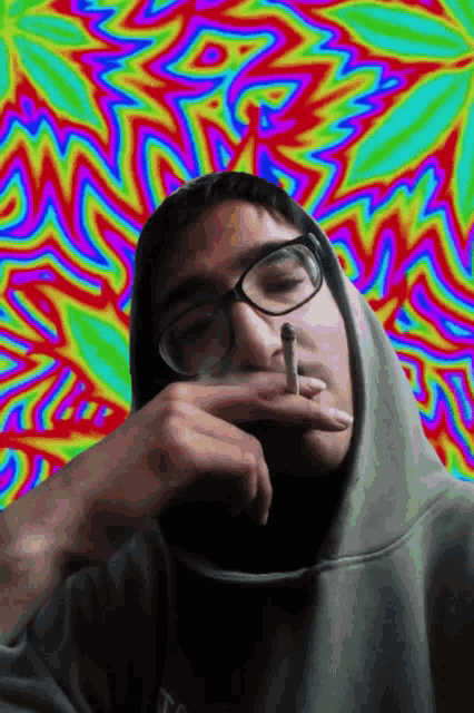 a man wearing glasses is smoking a cigarette in front of a psychedelic background