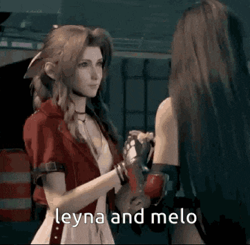 two women are standing next to each other in a dark room and talking to each other .