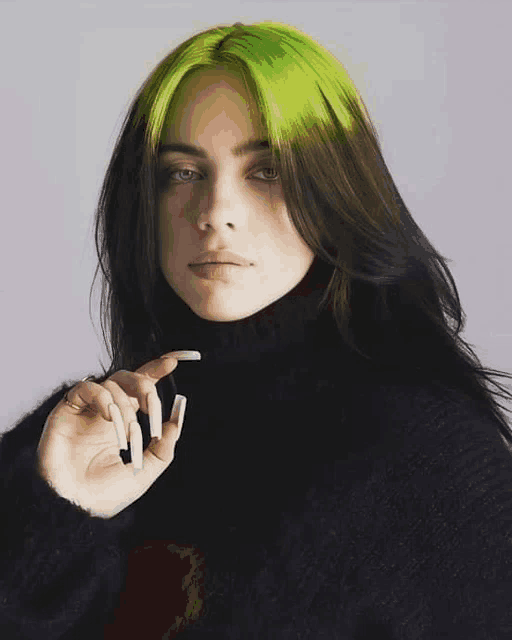 billie eilish is wearing a black turtleneck sweater and has green hair