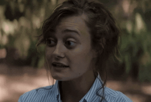 a close up of a woman 's face with a striped shirt on