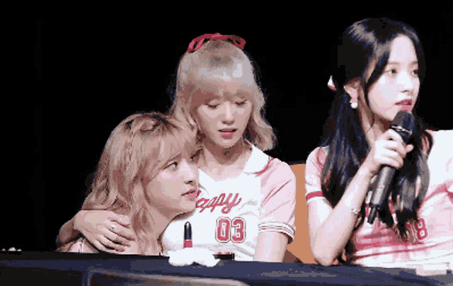 a girl wearing a jersey with the number 03 is hugging another girl