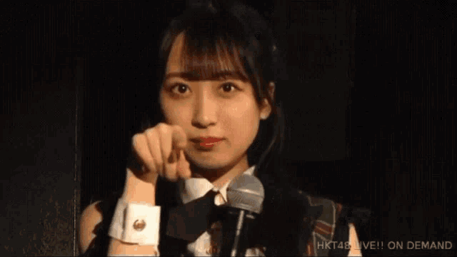 a woman is smiling while holding a microphone in front of her