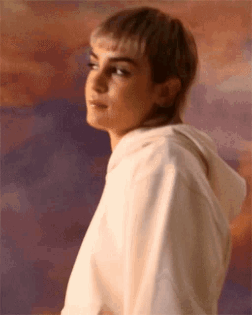 a woman with short hair is wearing a white hoodie