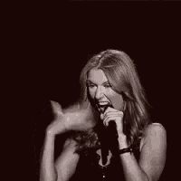 a woman is singing into a microphone with her mouth open .