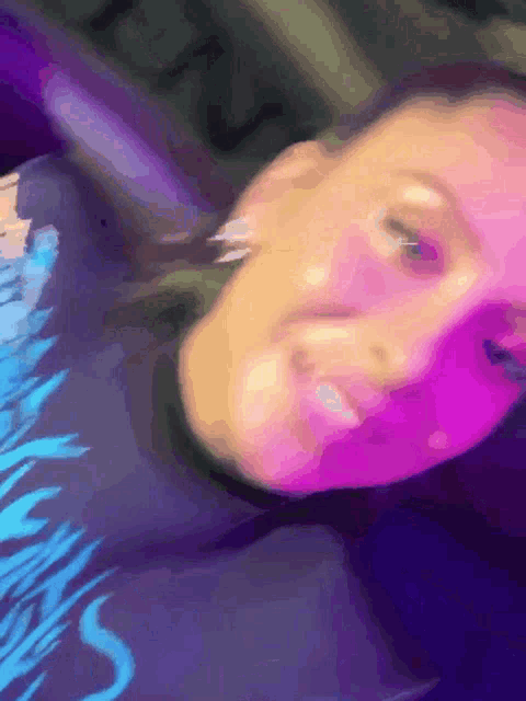 a close up of a person 's face with a purple and blue background
