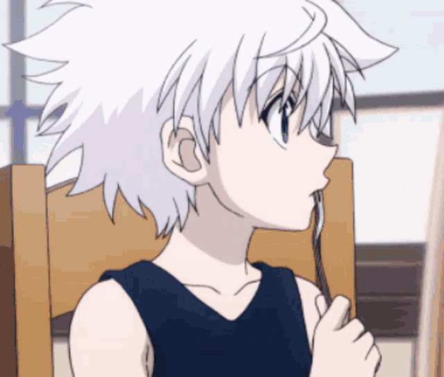 a boy with white hair is sitting in a chair