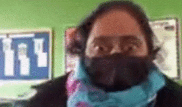 a woman wearing a black face mask and a scarf