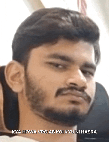 a man with a beard is making a funny face with the words `` kya howa vro ab koi kyu ni hasra '' .