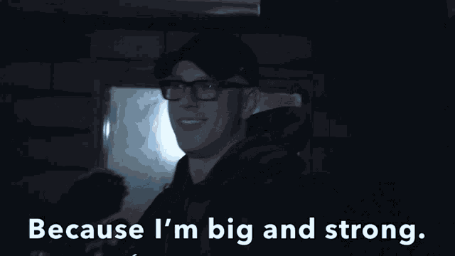 a man wearing glasses and a hat is smiling with the words because i 'm big and strong behind him