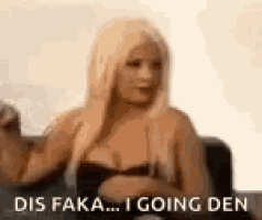 a woman in a black bra is sitting on a couch with her arms crossed .