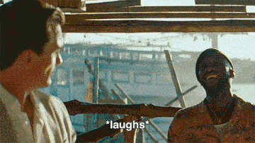 two men are laughing in front of a boat and the word laughs is on the screen