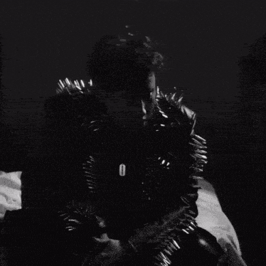 a black and white photo of a leather jacket with spikes